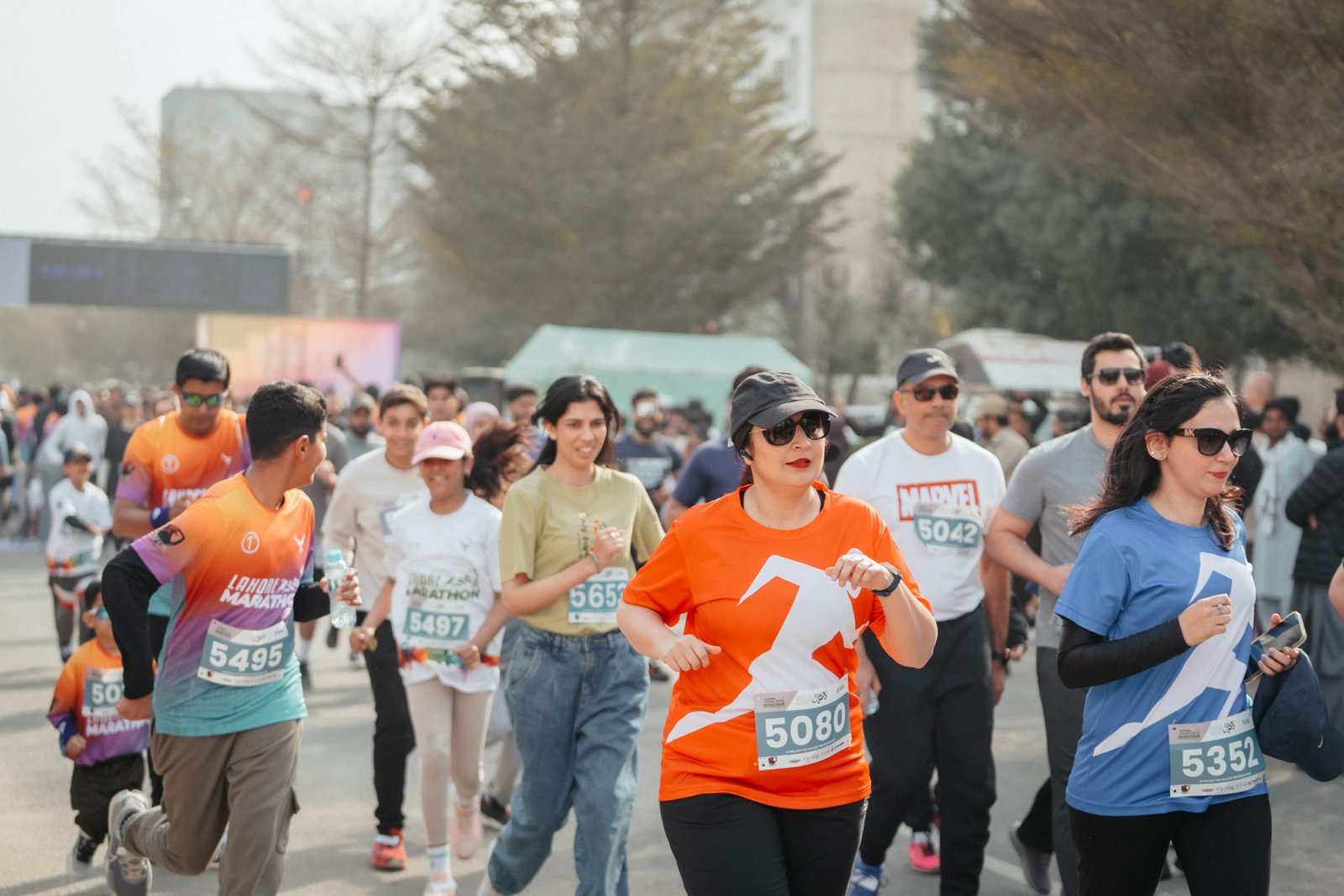 A mixed field of Lahore Marathon runners wearing race bibs